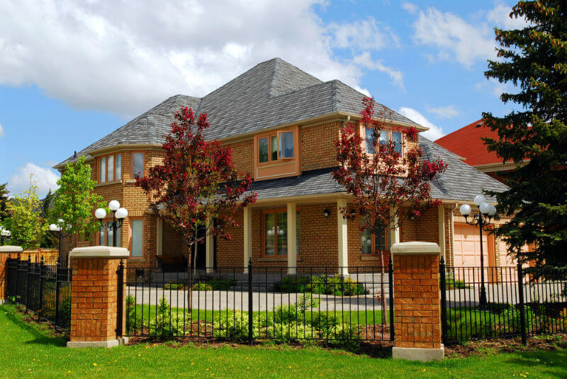 large luxurious residential home with iron fence