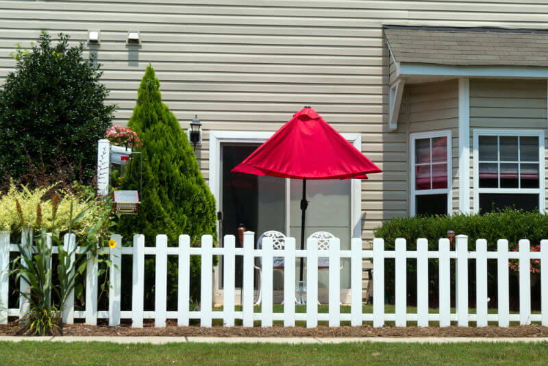 backyard vinyl fence with red umbrella