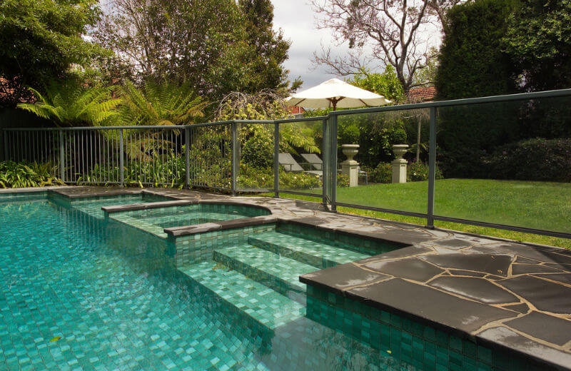 contemporary pool with glass fencing